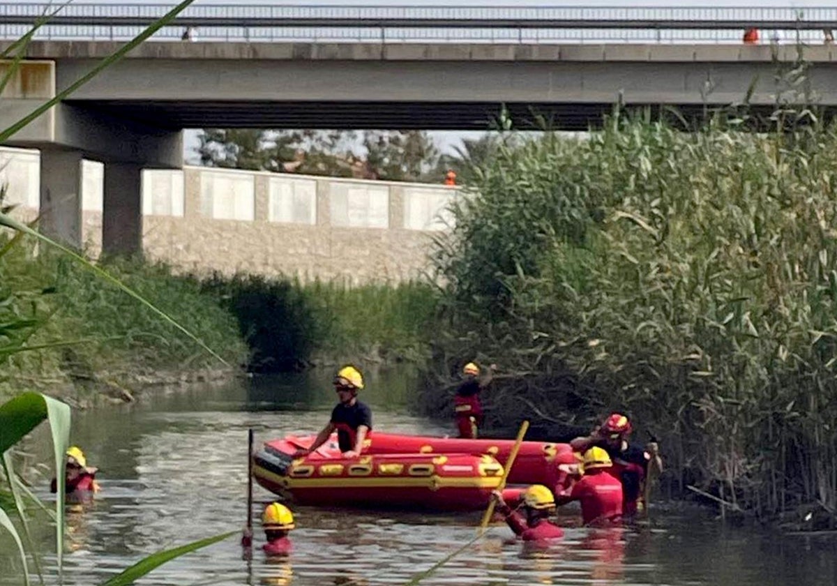 Equipo de Bomberos en tareas de baldeo en el río Segura en la zona donde han hallado el cuerpo del adolescente muerto, este martes.