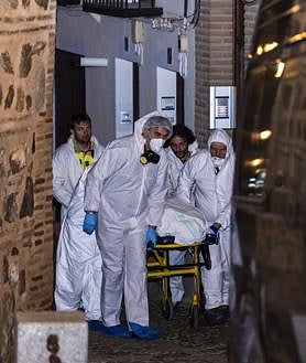 Imagen secundaria 2 - Miembros de los servicios funerarios trasportan uno de los cuatro cadáveres encontrados este martes en la calle Santa Leocadia de Toledo