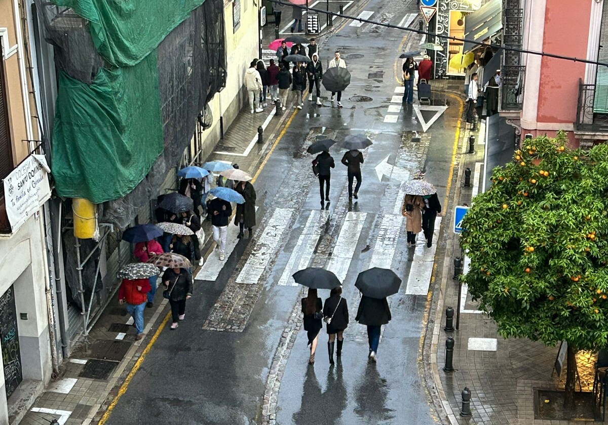 Paseantes bajo la lluvia el lunes por la tarde en la Plaza del Realejo de Granada