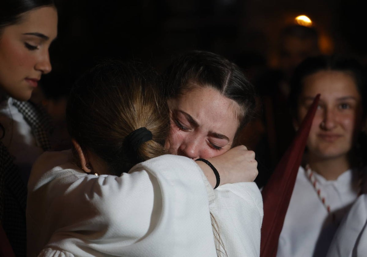 Dos hermanas del Descendimiento se abrazan desconsoladas tras la suspensión de la estación de penitencia, el Viernes Santo