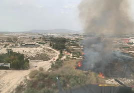 Los bomberos trabajan en la extinción de un incendio en Molina de Segura (Murcia) que ha provocado una gran columna de humo