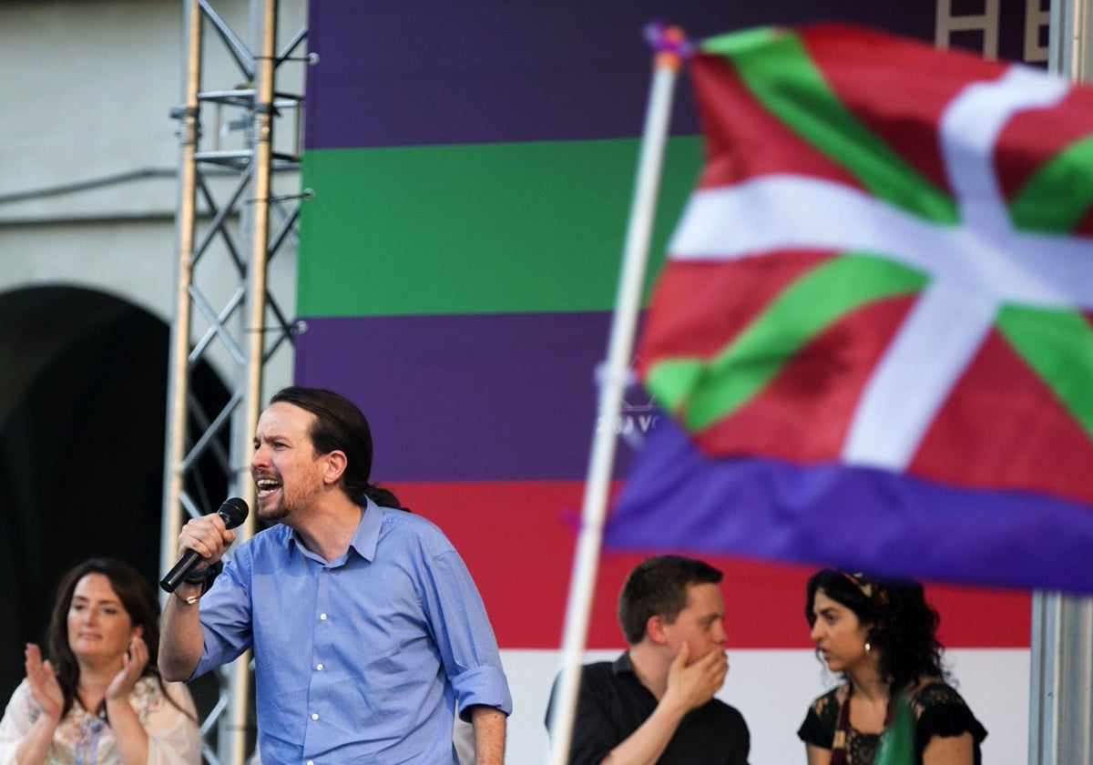 El fundador de Podemos Pablo Iglesias en un mitin junto a una ikurriña