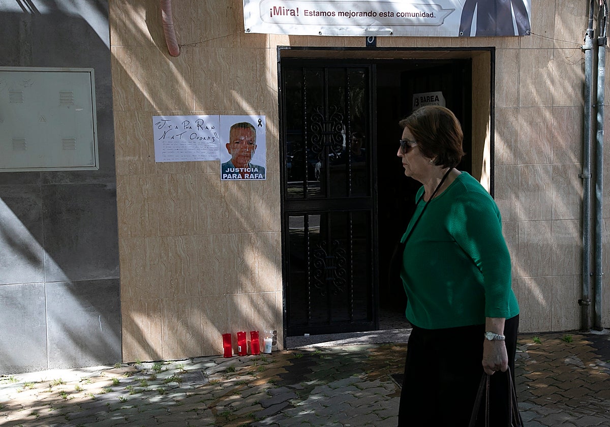 Una mujer pasa delante del portal donde vivía la primera víctima, Rafael, de 62 años