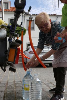 Vecinos de Sierra Boyera rellenando garrafas de agua de un camión
