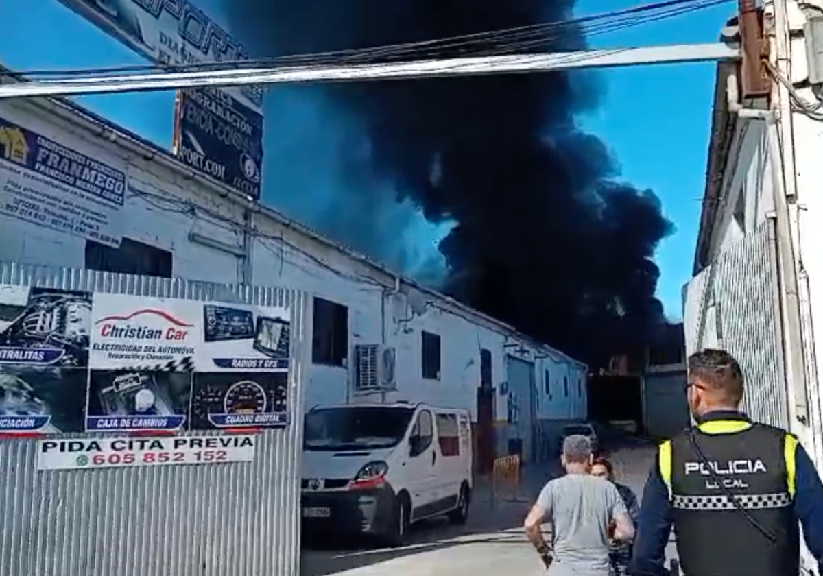 Densa cortina de humo que sale de la nave incendiada este domingo en Lucena