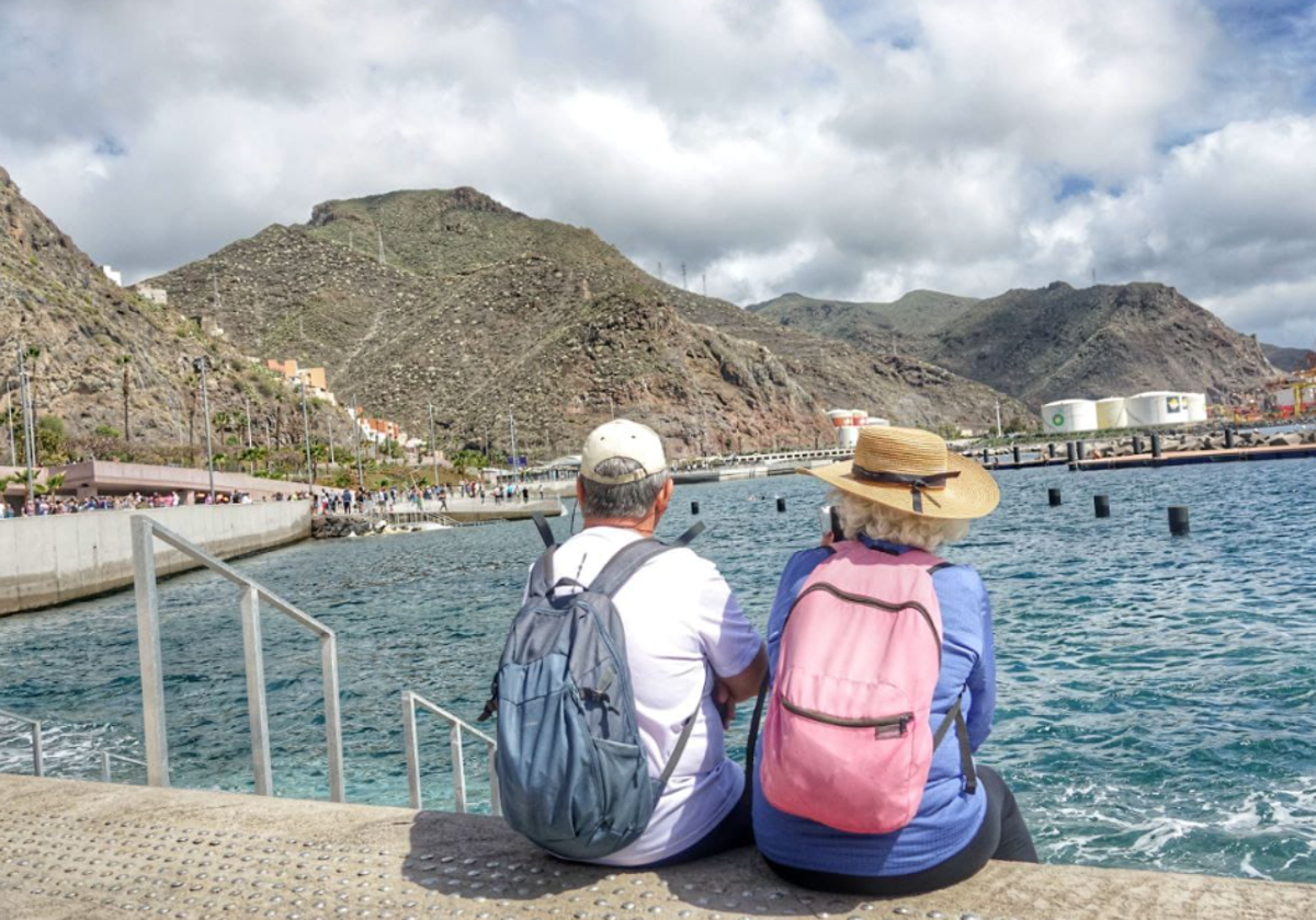 Dos personas descansan la en la zona de baño de Los Charcos, en Valleseco