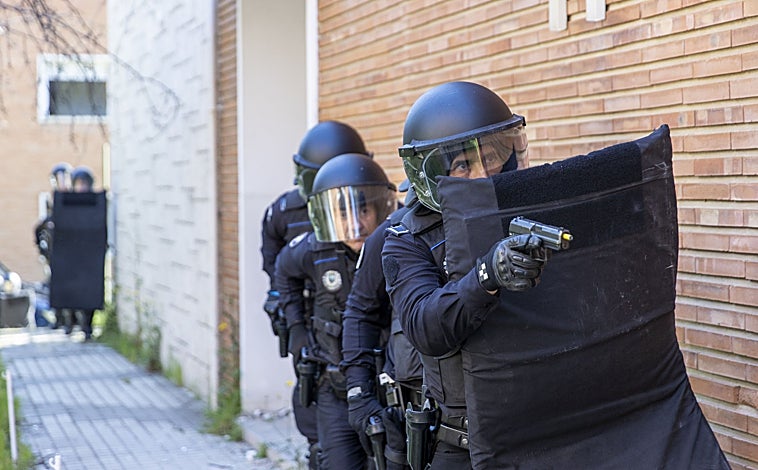 Imagen principal - Dos binomios de la CCS, los antidisturbios del Cuerpo local, se acercan al edificio asaltado; los policías marcan el paso a los facultativos, ya dentro del inmueble; y los sanitarios atienden a un joven