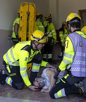 Imagen secundaria 2 - Dos binomios de la CCS, los antidisturbios del Cuerpo local, se acercan al edificio asaltado; los policías marcan el paso a los facultativos, ya dentro del inmueble; y los sanitarios atienden a un joven