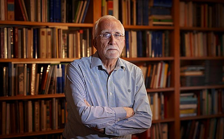 Imagen principal - Arriba, Luis Mateo Díez posa en el despacho de su casa en Madrid. Abajo, con su hermano Antón en la etapa escolar y, a la derecha, la estación de Villablino