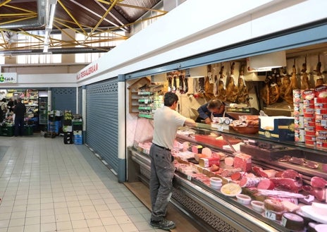 Imagen secundaria 1 - En la imagen superior, el concejal Juan Marín conversa con una de las clientas de la pescadería. Abajo a la izquierda, Manolo, el charcutero atiende a un cliente. A la derecha, entrada al mercado municipal