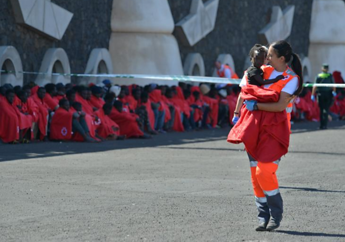 Un miembro de Cruz Roja atiende a un bebé llegado en cayuco a La Restinga, El Hierro, el pasado sábado