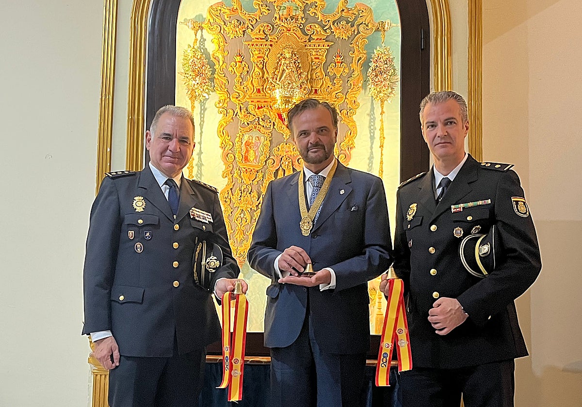 El comisario Vidal, el hermano mayor Alberto Jiménez y el inspector jefe Villaverde con las campanitas y lazos conmemorativos