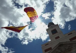 Un paracaidista sobrevuela la sede de la Comunidad de Madrid durante el acto cívico-militar en homenaje a los Héroes del Dos de Mayo