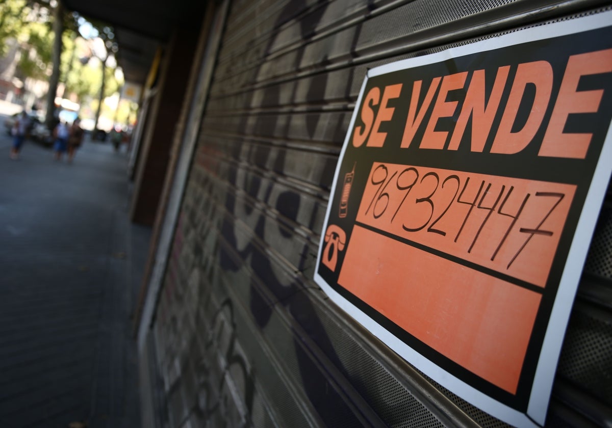 Un cartel de 'se vende' en un comercio cerrado de Madrid