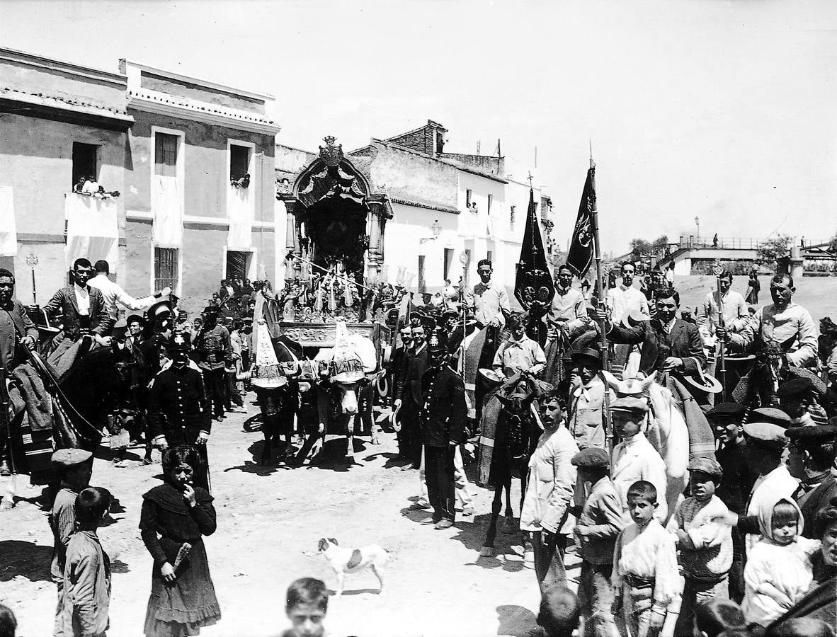 La Hermandad del Rocío escoltando a la tradicional carreta de la imagen al salir de las calles de Triana. Periodo: 05/1910