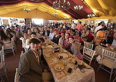 Imagen secundaria 1 - Arriba, Andrew Pocrid con sus modelos; debajo, una caseta llena durante el mediodía de este sábado y a la derecha, dos mujeres sobre un carruaje de tradición