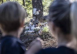 Dos personas ante el altar de Asunta en la pista forestal de Teo donde se dejó el cadáver