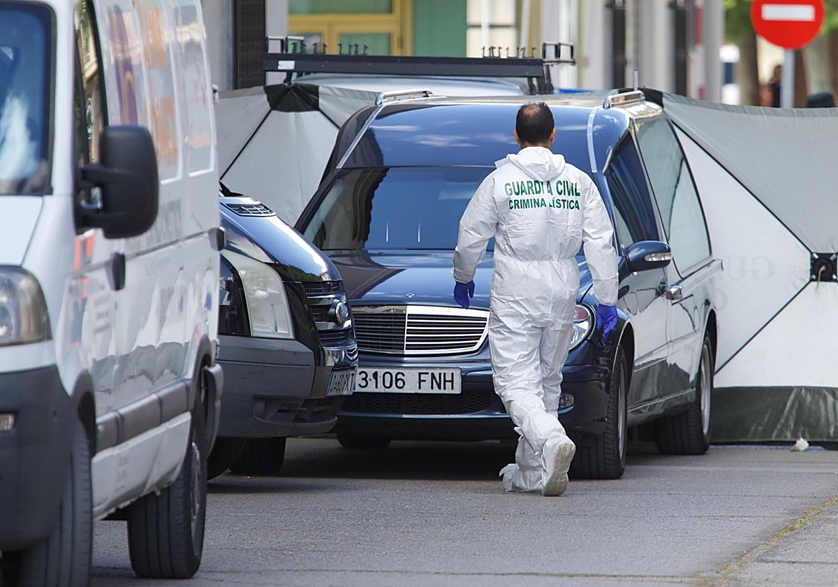 Un agente de la Unidad Criminal de la Guardia Civil , ante un coche que trasladará a algún fallecido