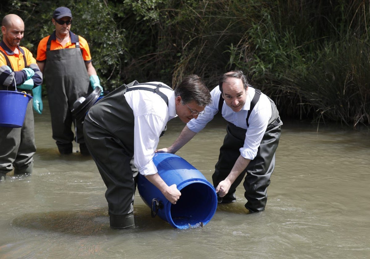 El delegado de Urbanismo, Medio Ambiente y Movilidad, Borja Carabante (dcha.), durante la suelta de peces en el río Manzanares