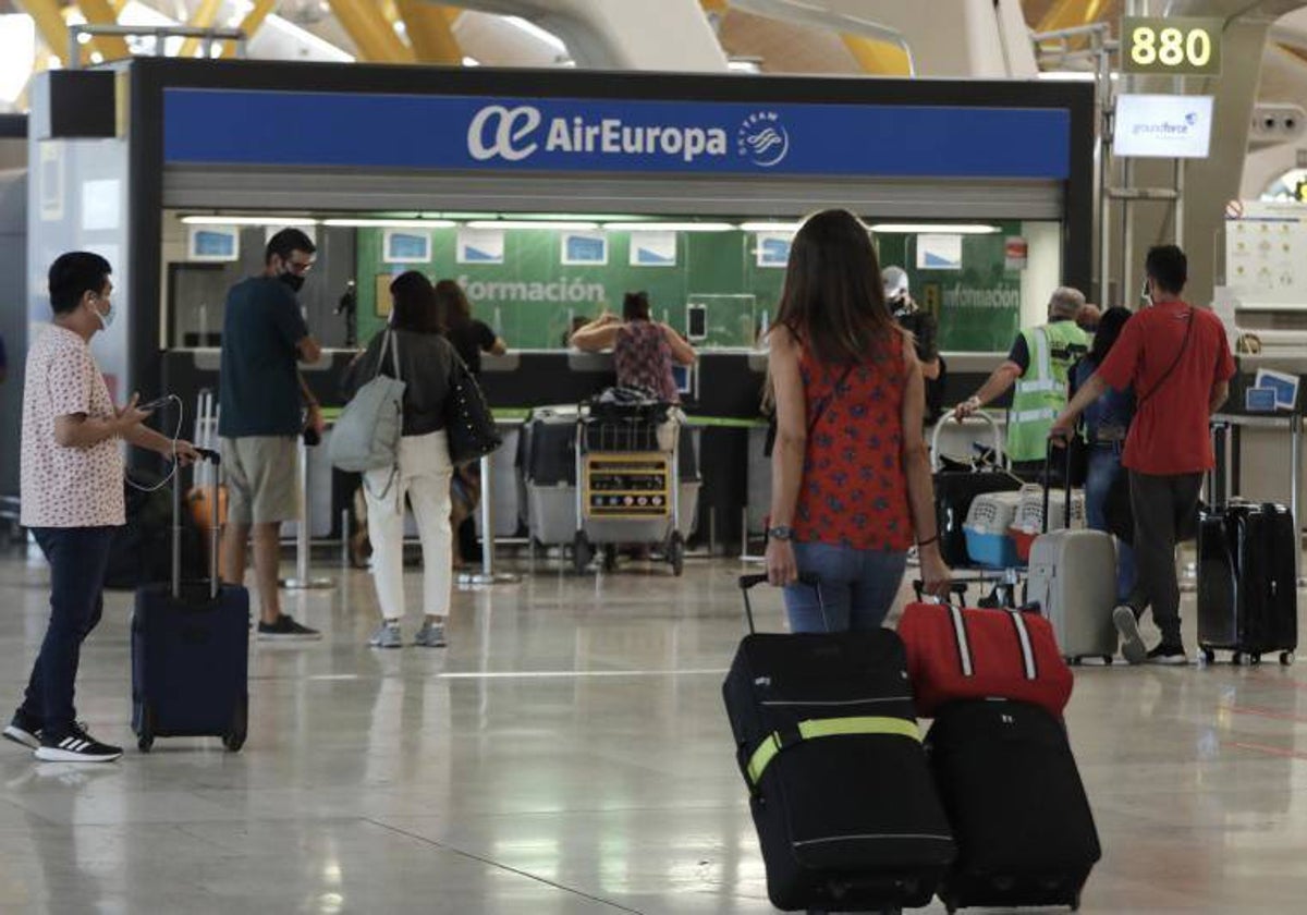 Varios viajeros, frente a un punto de información en un aeropuerto