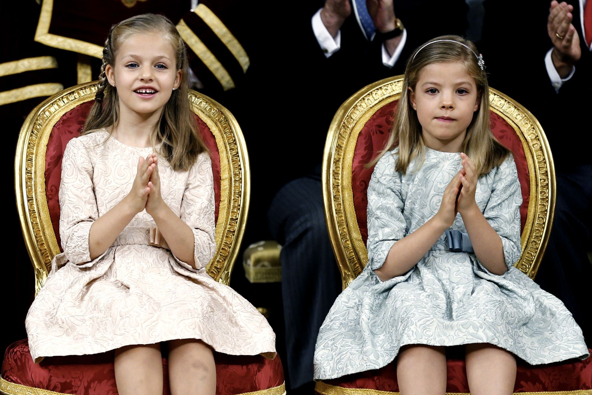 La Princesa Leonor, sentada junto a su hermana, la Infanta Sofía, durante la ceremonia de proclamación del Rey Felipe VI celebrada en el Congreso de los Diputados. Las menores llevaban vestidos iguales, pero en diferentes tonos pastel, que fueron confeccionados por las modistas asturianas Nieves García Torres y Teresa Fernández Castro. Tanto la Princesa como la Infanta protagonizaron varias anécdotas, sobre todo de protocolo, debido a su corta edad. Aún así, supieron cumplir, en todo momento, con las indicaciones de los Reyes. En el discurso de proclamación del Rey, a las menores, en más de una ocasión, se le escaparon sonrisas y aplausos, sobre todo cuando Don Felipe mencionó a la Princesa Leonor como Heredera a la Corona y cuando divisaron a su abuela, la Reina Sofía, en el hemiciclo, tras el reconocimiento público que le hizo Don Felipe. Ese segundo aplauso a Doña Sofía fue uno de los más largos de todo el discurso del Rey.