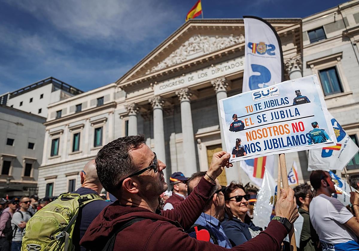 Un agente muestra un cartel de protesta durante una manifestación