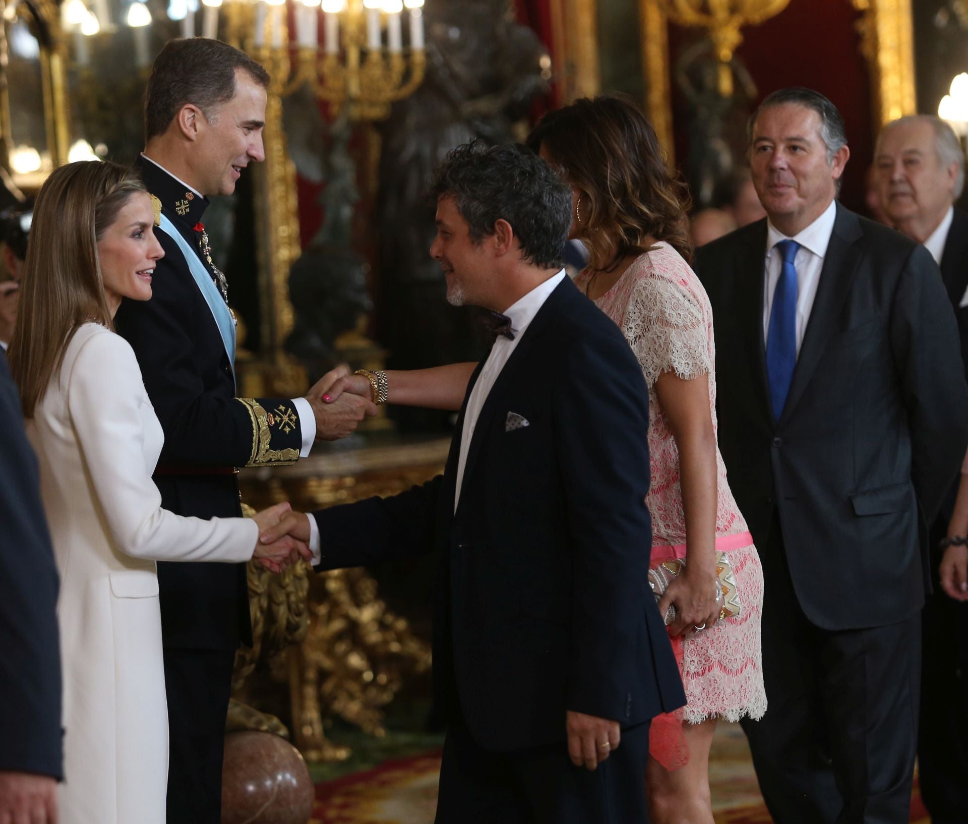 Alejandro Sanz fue otra de las caras conocidas que acudió a la recepción del Palacio Real para homenajear a los nuevos Monarcas. En esta imagen se observa cómo el cantante saluda a Doña Letizia. A su lado se encontraba su mujer, entonces embarazada de su segunda hija, Raquel Perera, quien aparece saludando a Don Felipe.