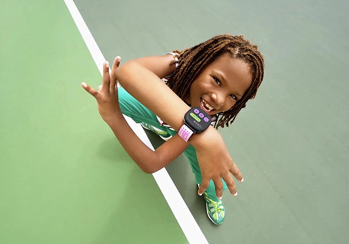 Una niña muestra un reloj de Google para activar el ejercicio de los niños