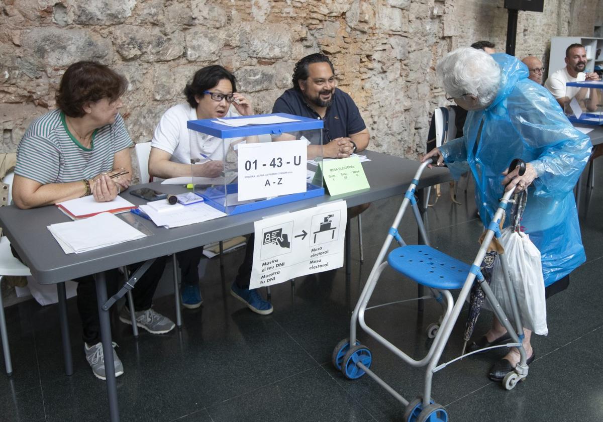 Una mujer se dispone a votar en el colegio electoral dispuesto en el Convento de San Agustí, en Barcelona