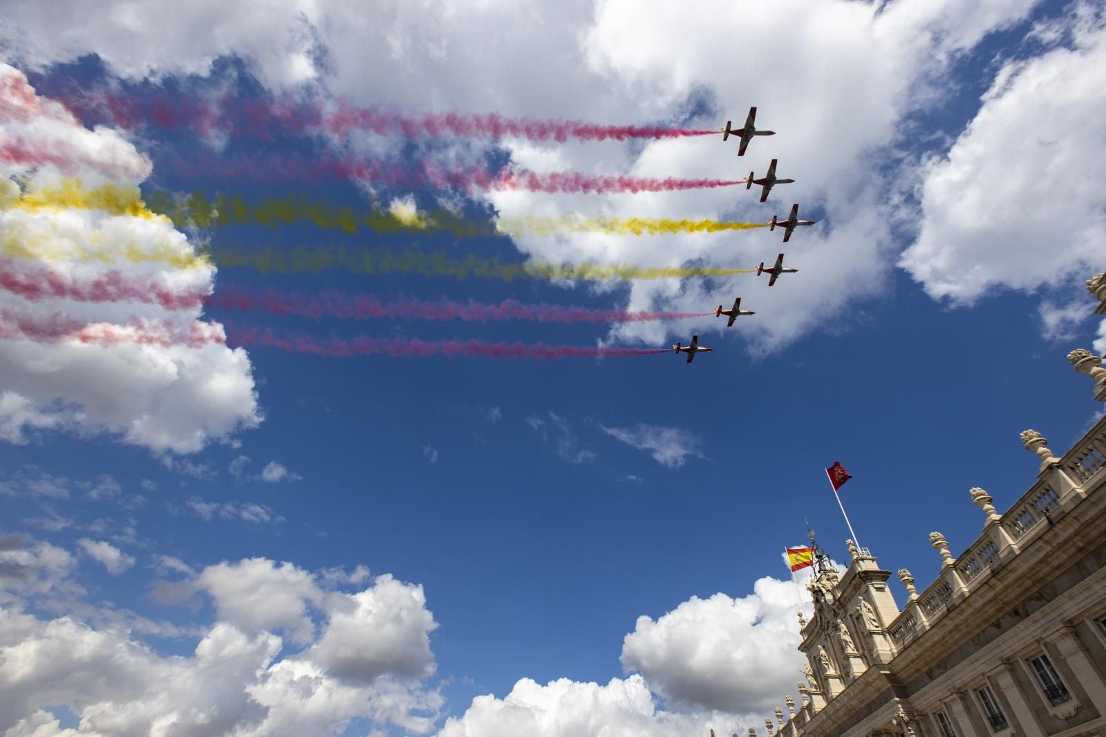 La Patrulla Águila, la unidad acrobática del Ejército del Aire y del Espacio, ha abierto los actos con una pasada sobre el Palacio Real pintando en el cielo los colores de la bandera de España