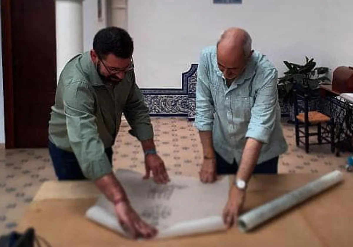 El hermano mayor, José Luis del Pino, observa los diseños con el bordador Manuel Solano, en el taller