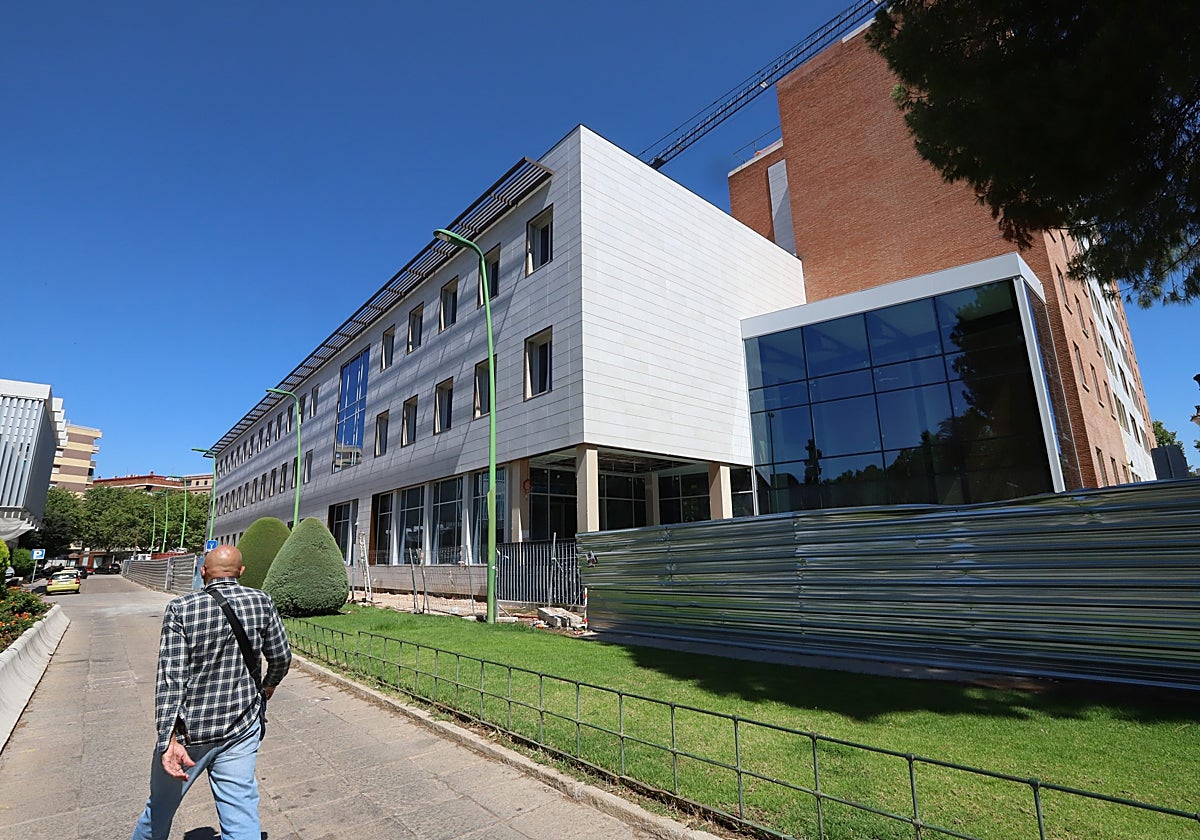 Un hombre pasea delante del acceso principal que tendrá el nuevo edificio de la Junta en Córdoba
