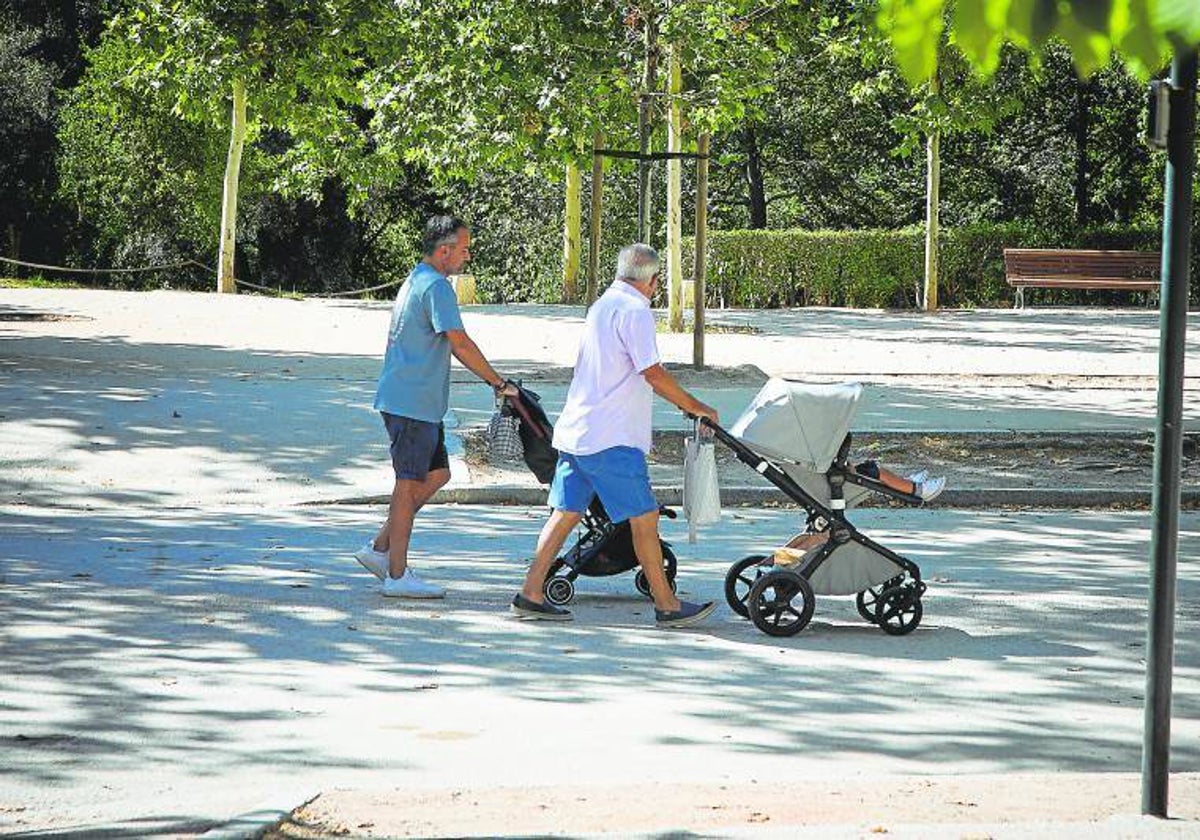 Dos personas pasean carros de bebé