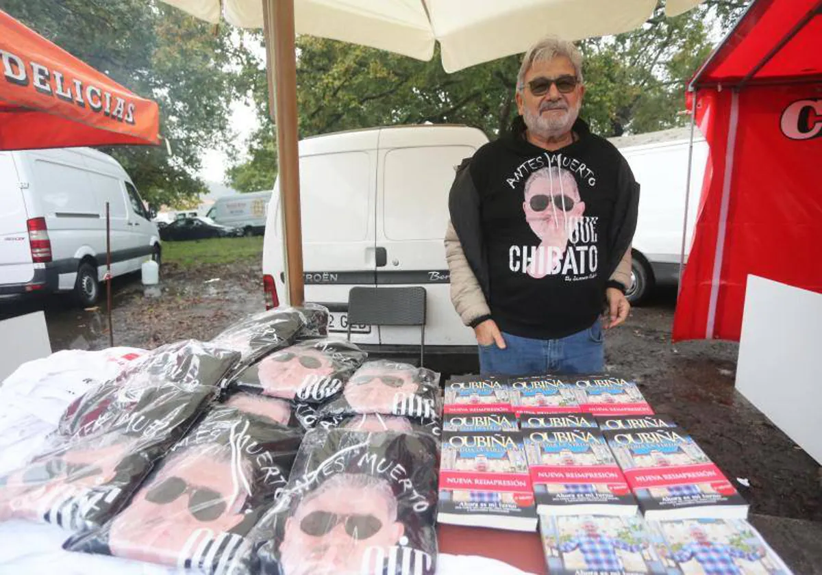 Laureano Oubiña sells his books and t-shirts with a face at a fair, in a 2019 image