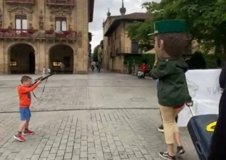 Imagen secundaria 1 - En el pueblo hay anuncios del Fan Hemendik, una celebración que exige el abandono de este cuerpo y se representa con una flecha sinuosa que, de lado, parece una pistola. Abajo a la izquierda, un fotograma del vídeo de un niño en Oñate apuntando a un cabezudo guardia civil