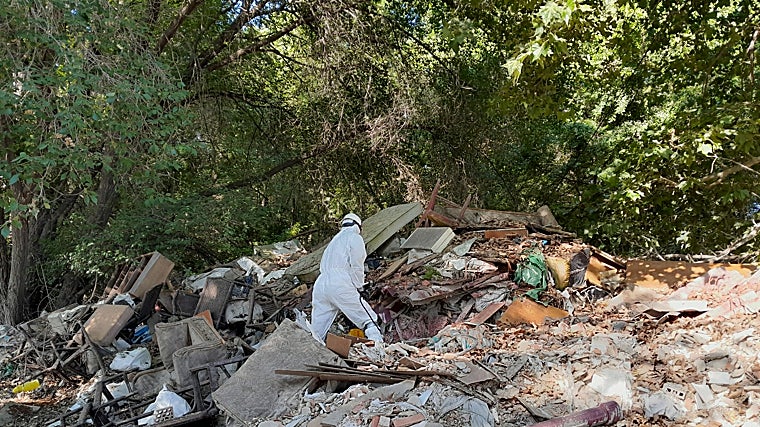 Un operario recoge los residuos del entorno del río Jarama