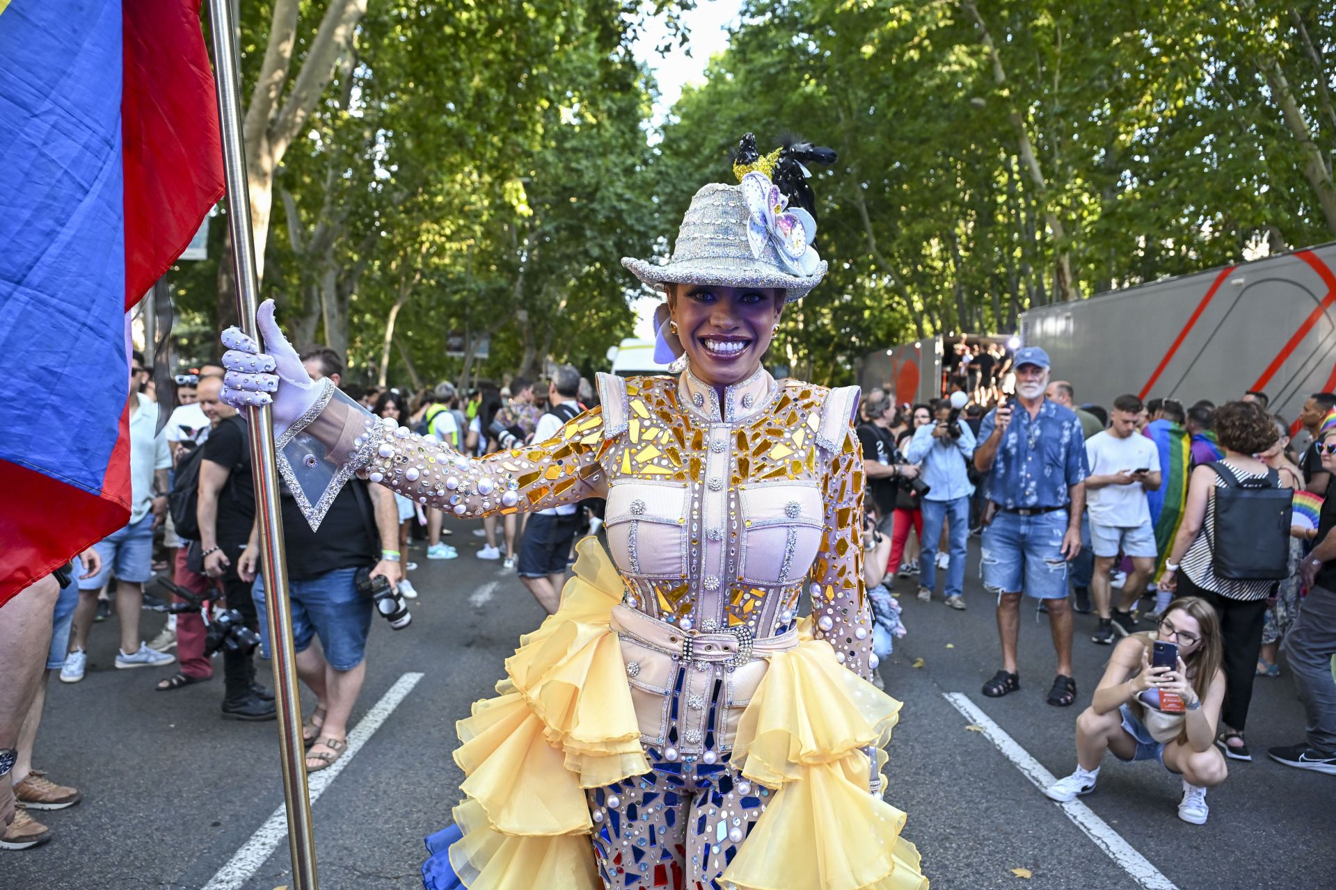 Una asistente luce un traje con el tricolor amarrillo, azul y rojo y un sombrero con un ave en la cabeza durante la manifestación