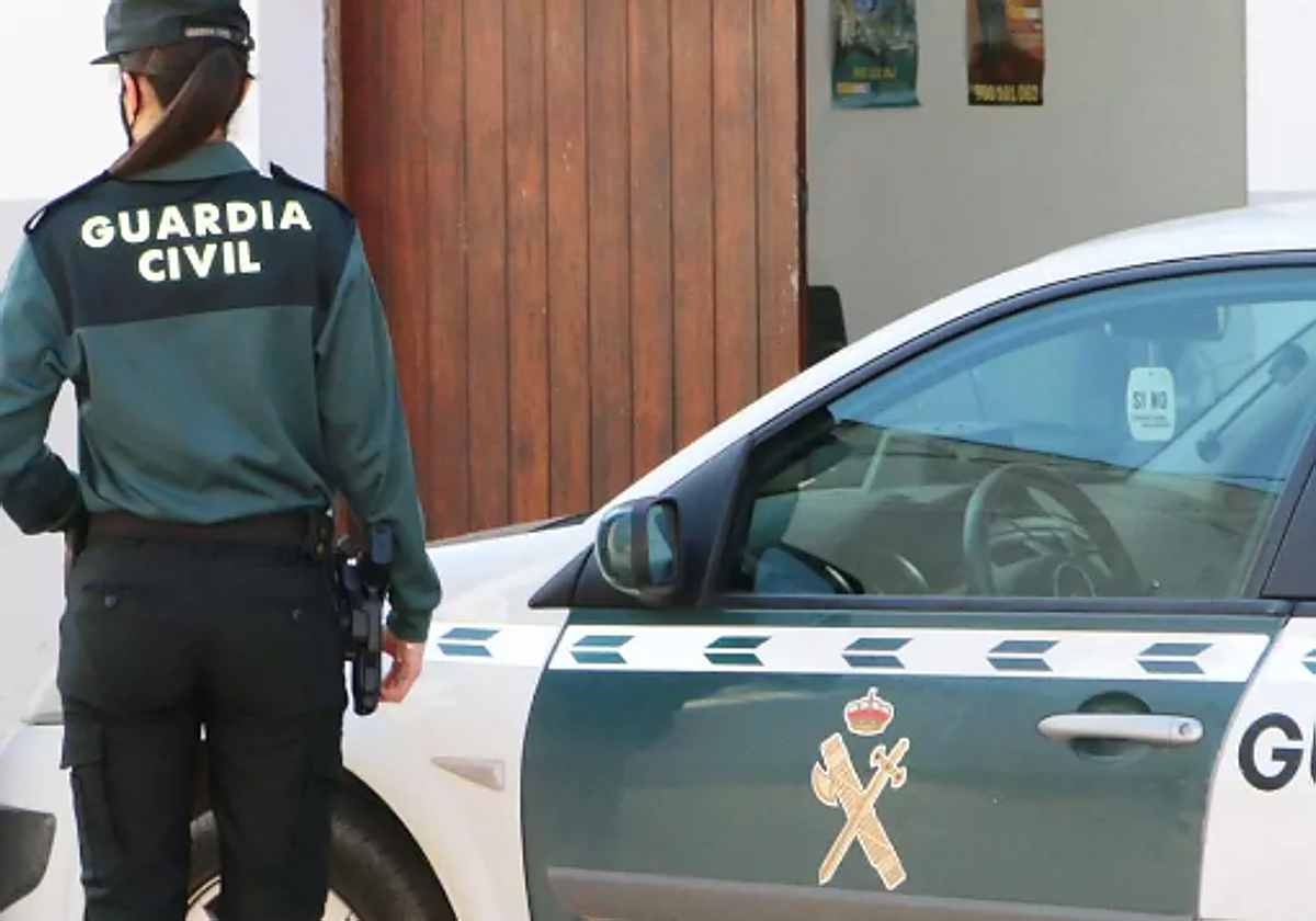 Agente y coche de la Guardia Civil
