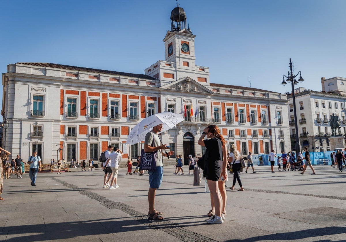 Turistas frente a la Real Casa de Correos, sede del Gobierno de la Comunidad de Madrid, en la Puerta del Sol