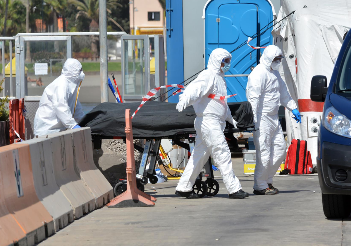 Trasladan a un migrante fallecido en una travesía en patera en el Puerto de los Cristianos en foto de 2021