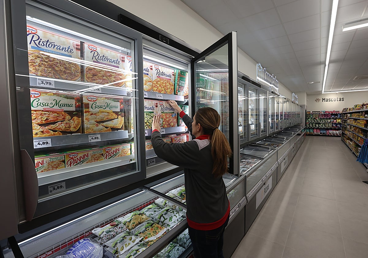 Una empelada de un supermercado en Córdoba coloca una serie de productos