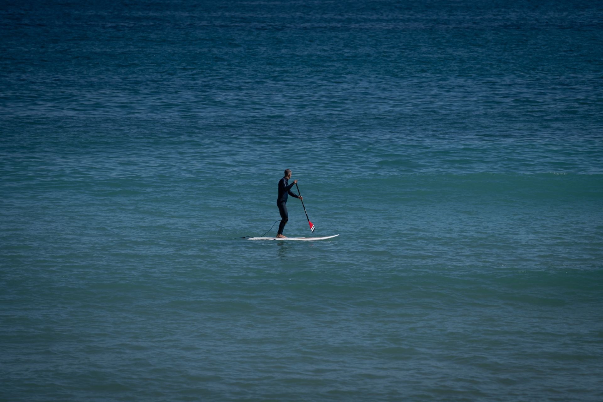 Un hombre practica paddle surf.