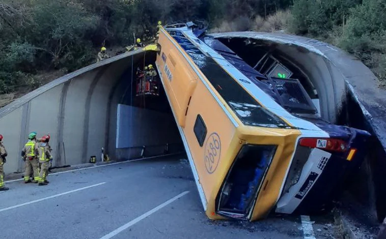 Imagen principal - EL bus accidentado este martes, a la entrada de un túnel, en la provincia de Barcelona