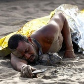 Dramática llegada de un cayuco a la playa de Las Burras (Gran Canaria) ante la mirada de bañistas