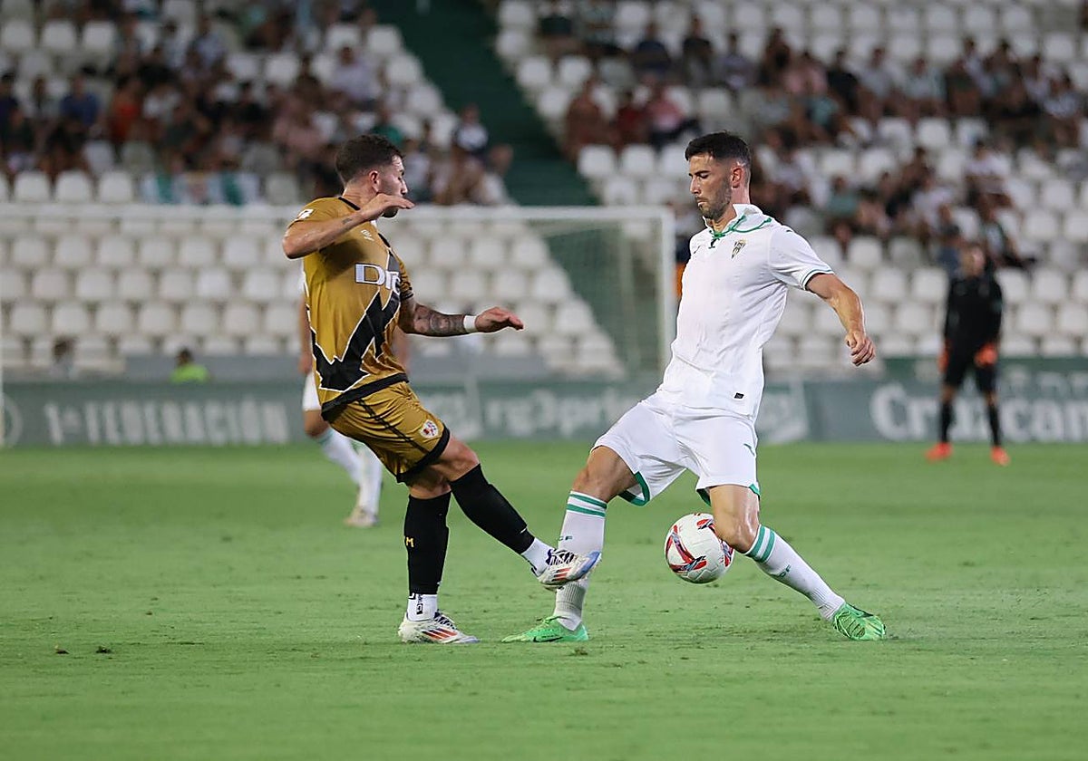 Carlos Albarrán defiende el balón ante un rival del Rayo Vallecano