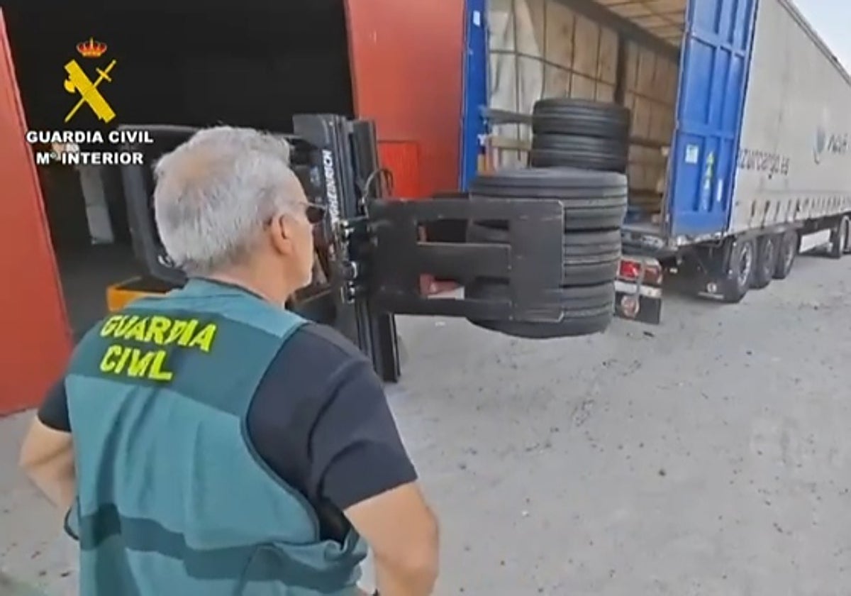 Un guardia civil junto a algunos de los neumáticos recuperados