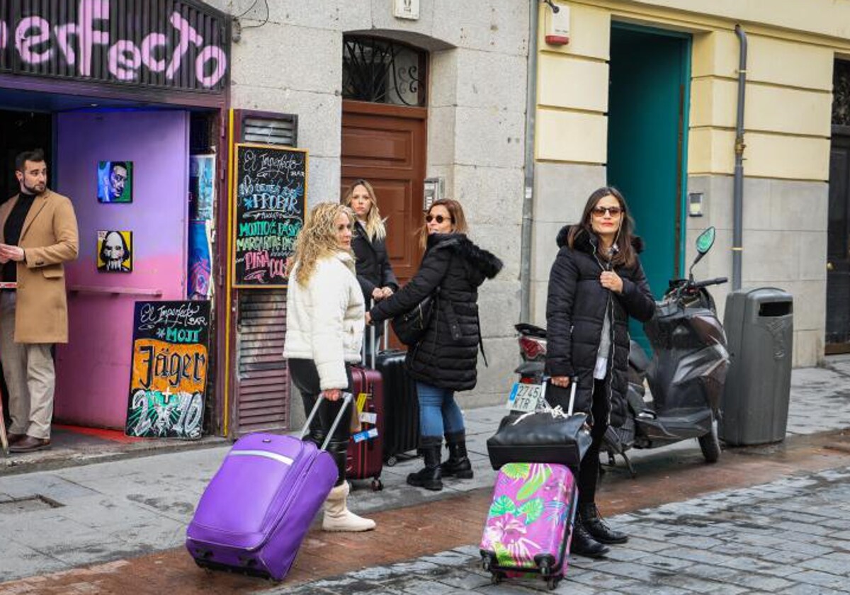 Un grupo de visitantes a las puertas de un piso turístico en Madrid