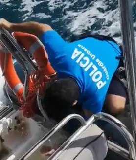 Imagen secundaria 2 - Arriba, una de las embarcaciones de Greenpeace, vista desde la barca policial. Abajo, los activistas desplegando las pancartas. Y, al a derecha, un urbano achicando agua de su lancha