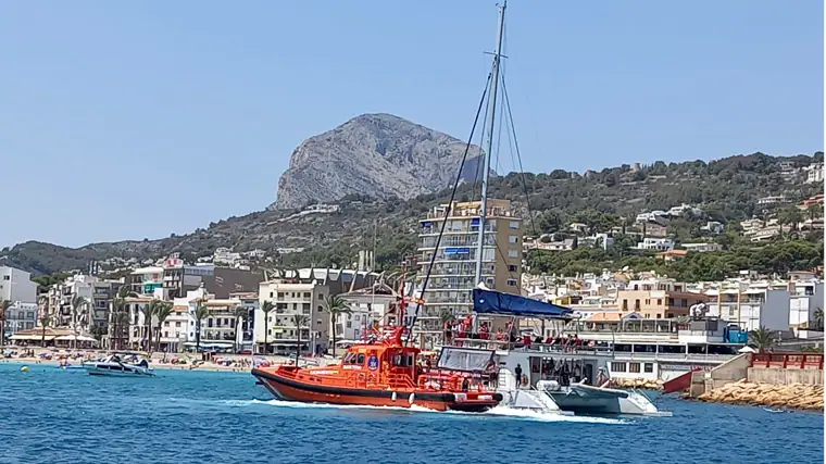 Un barco de Salvamento Marítimo remolcando al catamarán con 65 personas a bordo, tras encallar en el puerto de Jávea