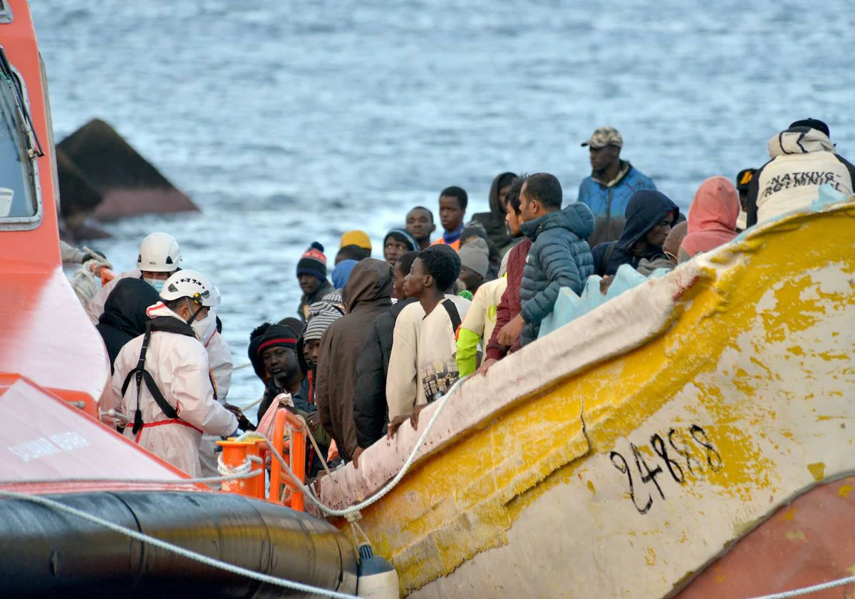 Miembros de Salvamento Marítimo atienden a migrantes de un cayuco que llegó a la isla canaria de El Hierro